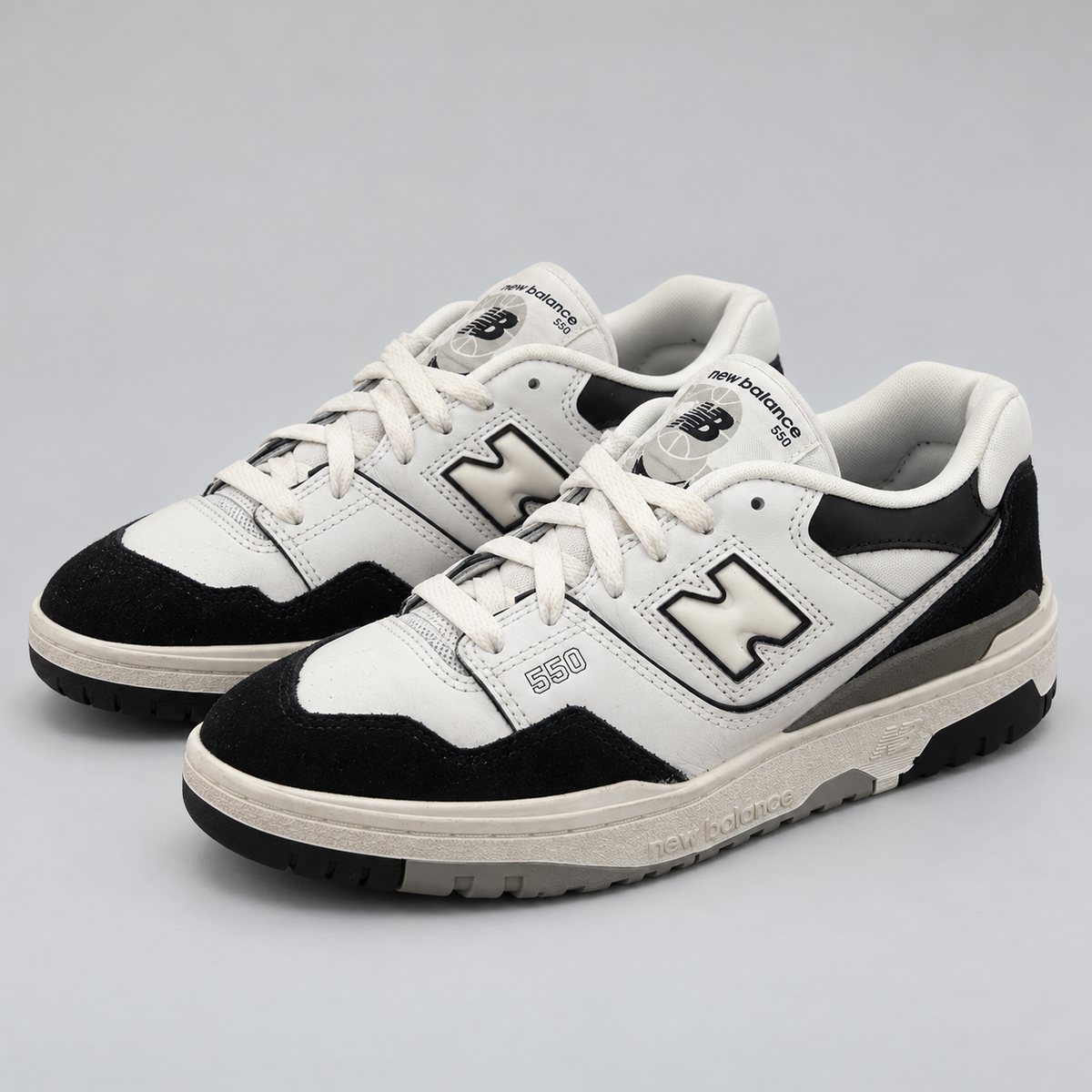New Balance 550 vit och svart, paret snett framifrån