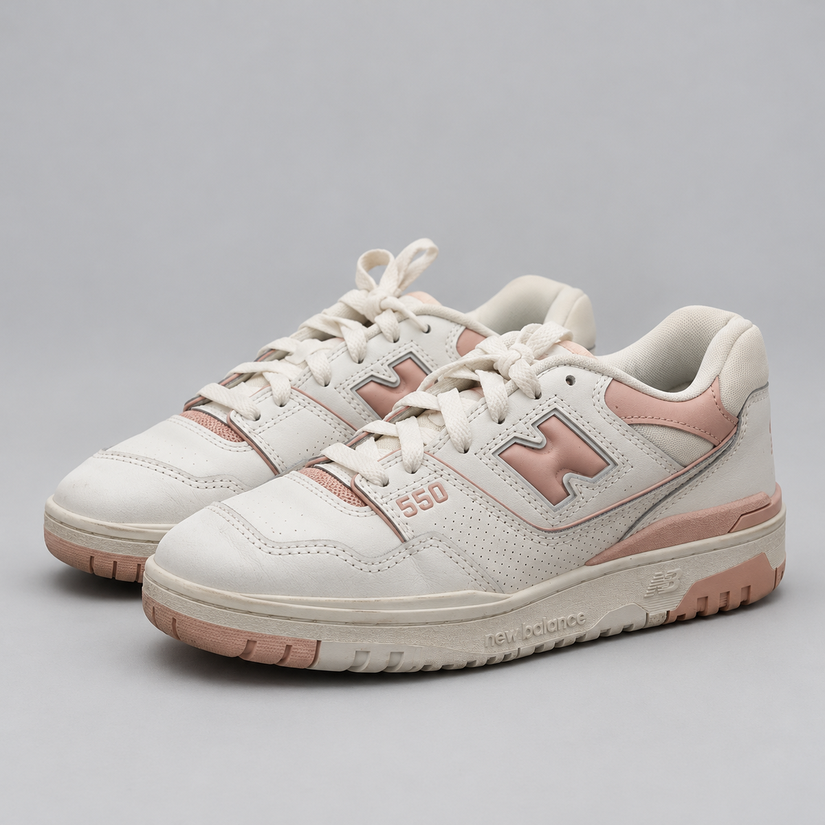 New Balance 550 vit och rosa, paret snett framifrån